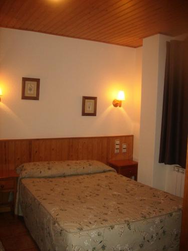 a bedroom with a bed and two pictures on the wall at Hostal Pernalle in Erill la Vall