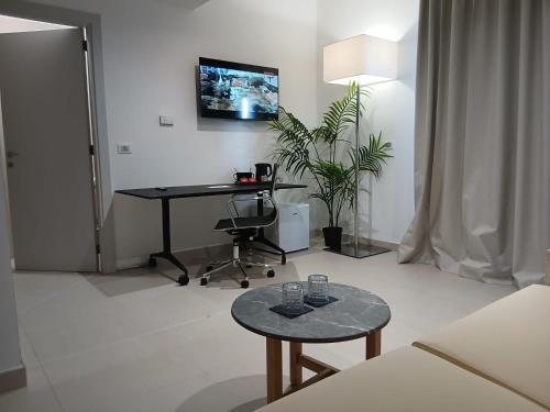 a living room with a desk and a table at LHI Healthy Hotel Lecce in Lecce