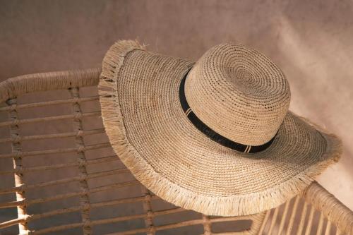 a straw hat sitting on top of a chair at La Bergerie à Palleau, Les Blés Dorés et Les Graines de Lin à Corgengoux, proches de Beaune et de ses villages viticoles in Palleau