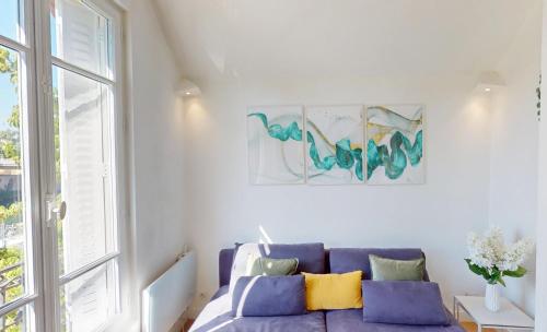 a living room with a purple couch and a window at Appartement 3 pièces proche Paris & Disney in Nogent-sur-Marne