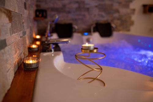 une bougie sur un comptoir dans une salle de bain avec baignoire dans l'établissement Aux 3 Glands - Nature & Spa, à Dieffenbach-au-Val