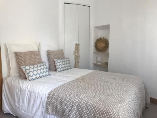une chambre avec un grand lit avec des oreillers dessus dans l'établissement L'ESCALE DUPLEX, Vue Château, CENTRE VILLAGE, à Cassis