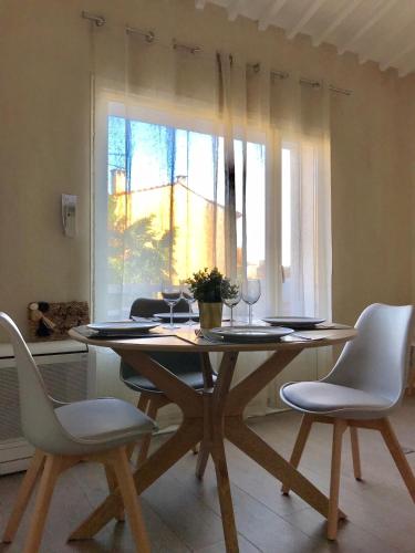 une table à manger avec des chaises et une fenêtre dans l'établissement L'ESCALE DUPLEX, Vue Château, CENTRE VILLAGE, à Cassis