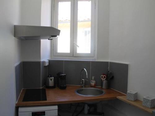 un comptoir de cuisine avec un évier et une fenêtre dans l'établissement L'ESCALE DUPLEX, Vue Château, CENTRE VILLAGE, à Cassis