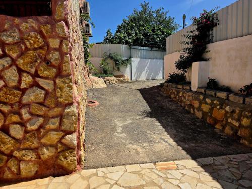 a stone wall next to a walkway in a yard at Charming Farmhouse for Lease in Ed Deir