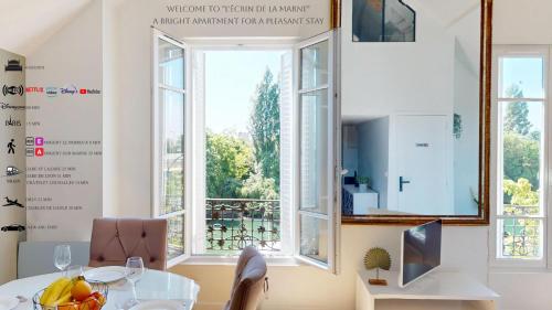 une salle à manger avec une table et une fenêtre dans l'établissement Appartement 3 pièces proche Paris & Disney, à Nogent-sur-Marne