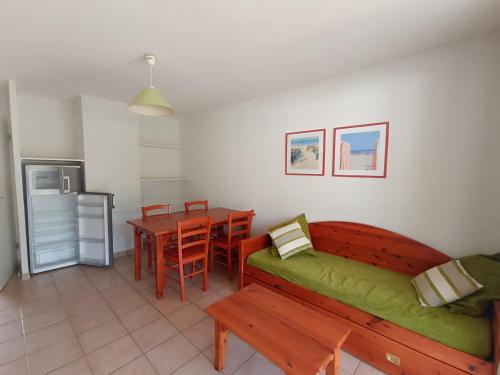 un salon avec un banc et une table ainsi qu'une cuisine dans l'établissement appartement dans residence avec piscine, à Soulac-sur-Mer