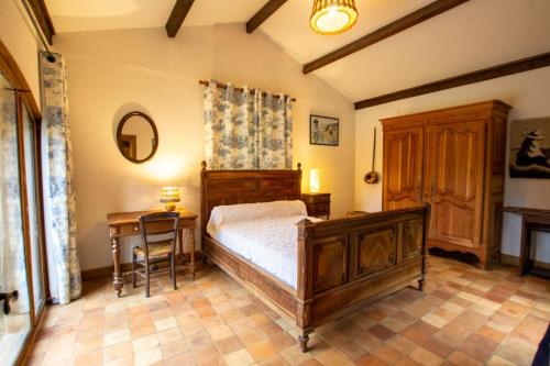 une chambre avec un lit, une table et un bureau dans l'établissement La mounerie, à Finsac