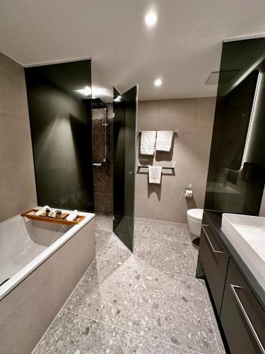 a bathroom with a tub and a sink and a toilet at Stadthotel Münster in Münster