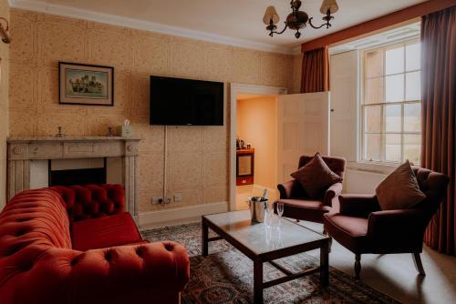 a living room with a couch and chairs and a tv at Swinton Park in Masham