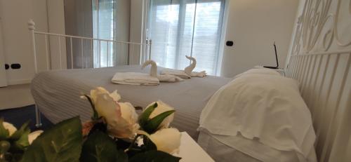 two swans sitting on a bed in a room at Residence Alessandra Supervacanza - Domaso in Domaso