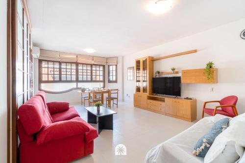 a living room with a red couch and a table at Mediterranean Way - Anguera in Cambrils