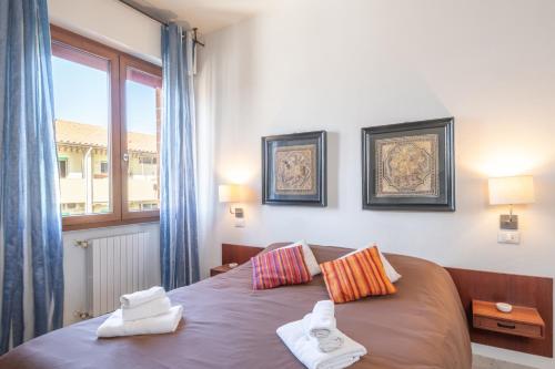 a bedroom with a bed with two towels on it at Piombino Apartments Casa Grazia in Piombino