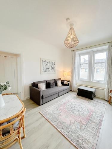 a living room with a couch and a table at Chic flat close to Edinburgh, Airport, & Zoo in Edinburgh