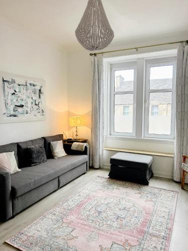 a living room with a couch and a window at Chic flat close to Edinburgh, Airport, & Zoo in Edinburgh