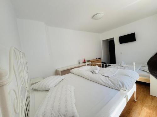 a white bed with white sheets and pillows in a room at Iancu Apartments in Bucharest