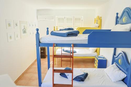 two bunk beds in a small room with a room with twothirdsebinebinebin at Albergue de São Bento in Caminha