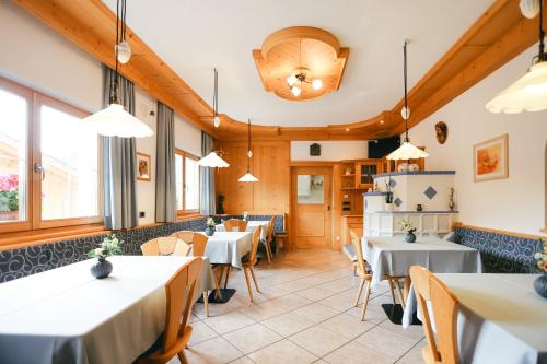 Un restaurante con mesas, sillas y ventanas. en Marxhof, en Barbiano