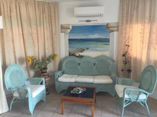 a living room filled with furniture and a painting at Palau City Hotel in Palau