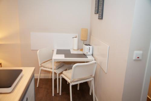 a small kitchen with a white table and chairs at WohnRaum Gäste- & Boardinghaus in Gusterath