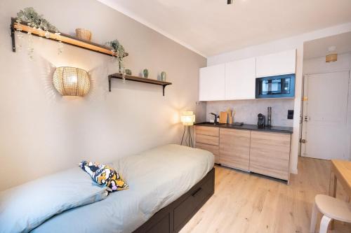 une petite chambre avec un lit et une cuisine dans l'établissement Beautiful studio near Eiffel Tower and Beaugrenelle, à Paris