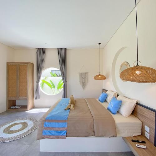TimuranにあるHoneymoon Villa Jogja - fulton Malehaの青い枕が付いた大きなベッドのある寝室