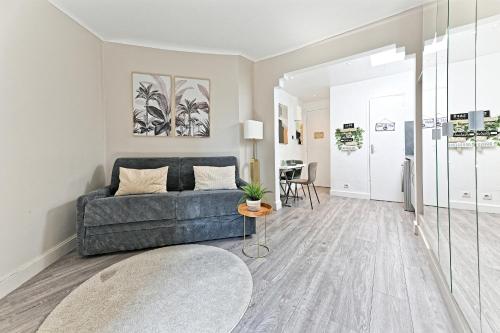 un salon avec un canapé et une table dans l'établissement Studio Terrasse vue incroyable sur Tour Eiffel, à Paris