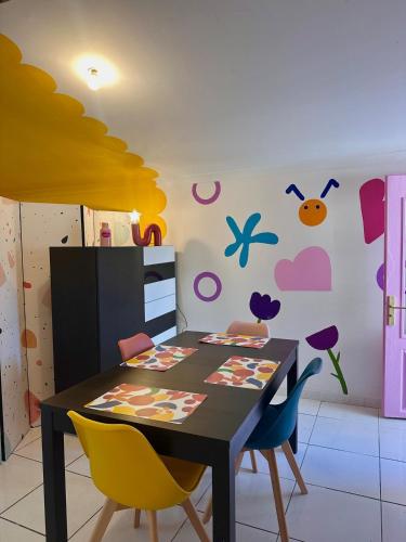 une salle à manger avec une table et des chaises dans l'établissement POP HOUSE - Appartement coloré et fun en Camargue, à Saint-Gilles