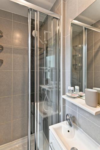 une salle de bain avec douche et lavabo dans l'établissement Studio Terrasse vue incroyable sur Tour Eiffel, à Paris