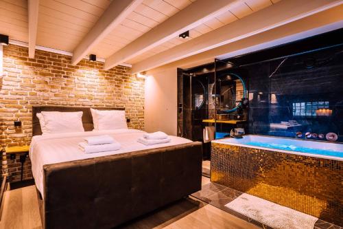 a bedroom with a large bed and a bath tub at Hotel de Prince in Nijmegen