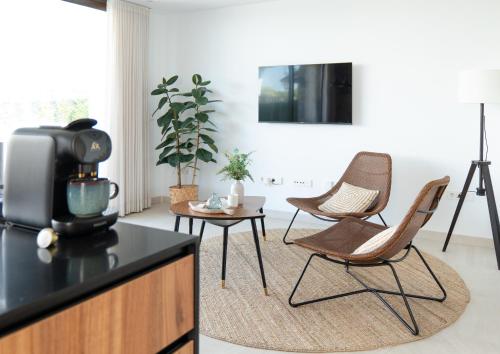 ein Wohnzimmer mit zwei Stühlen und einem Fernseher in der Unterkunft Modern Villa in Santa Rosalía with Rooftop View BY COELI HOME LIVING in Torre-Pacheco