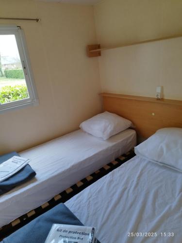 deux lits dans une petite pièce avec une fenêtre dans l'établissement Camping Del Padel, à Les Avenières