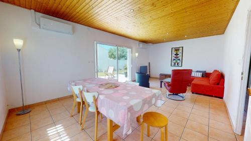une salle à manger avec une table, des chaises et un canapé dans l'établissement Le Clos du Cep, à Saint-Hilaire-de-Riez