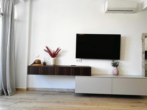 a living room with a flat screen tv on a wall at Sunny apartment Carihuela in Torremolinos