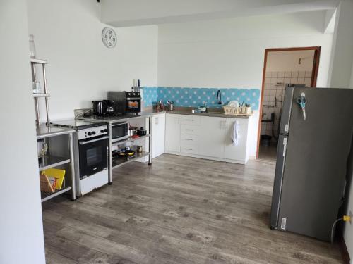 a kitchen with a stainless steel refrigerator and white cabinets at Alojamiento San Francisco - Apartamentos y habitaciones in Lima