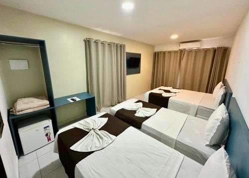 a hotel room with three beds in it at Pousada Caribe Brasileiro in Maragogi