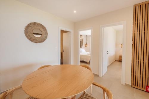 a dining room with a wooden table and a bedroom at House Eleni in Agios Georgios Pagon