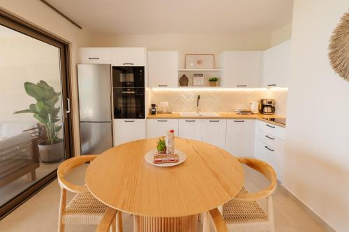 a kitchen with a wooden table and chairs in a kitchen at House Eleni in Agios Georgios Pagon