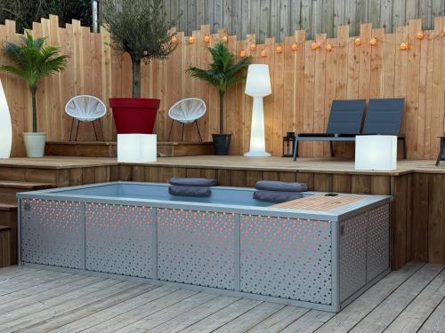 a patio with a bench and a table at Magnifique Villa avec jacuzzi les 44Hectares in Cap-Ferret