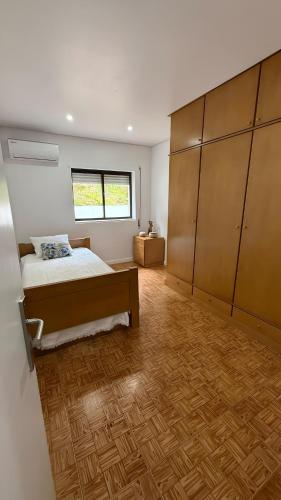 a bedroom with a bed and a wooden floor at Casa de campo do Rojão do Meio in Mesão Frio
