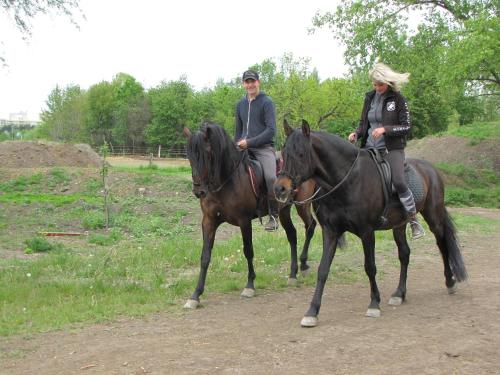 two people riding on horses on a dirt road at Rivendell Apartments in Prague