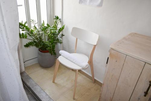 a white chair sitting in a room with a plant at Daniela Village House in Keri
