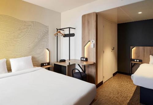 a hotel room with a bed and a desk at B&B HOTEL Cergy Saint Christophe in Cergy