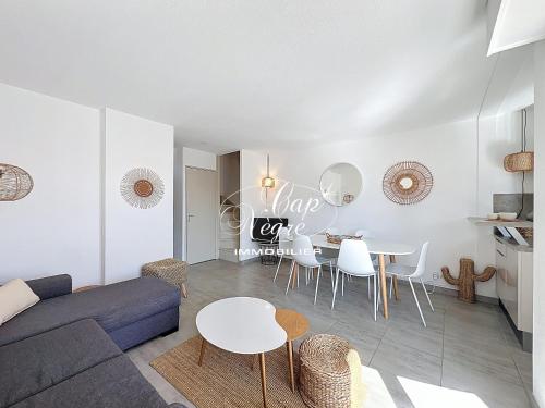 un salon avec un canapé, une table et des chaises dans l'établissement Appartement classé 3 étoiles avec terrasse à 150 m plage de Cavalière - LE LAVANDOU, au Lavandou