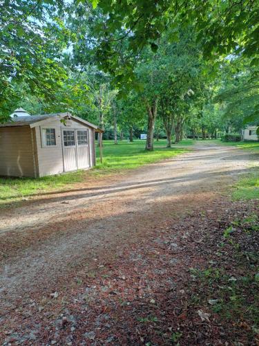 un chemin de terre avec un petit bâtiment sur le côté dans l'établissement Camping Paradis Nature, à Ivoy-le-Pré