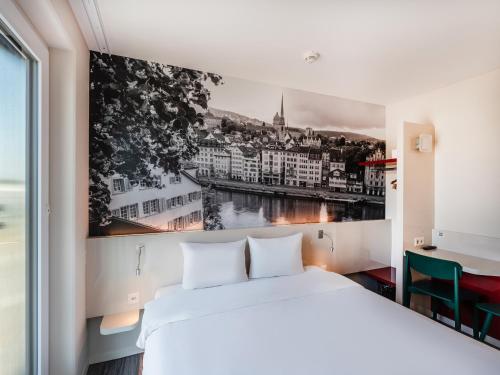 吕姆朗B&B HOTEL Zürich Airport的卧室里有一张白色的床，墙上挂着一幅画