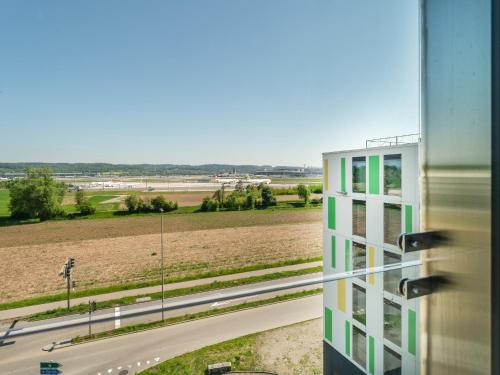 a building with a view of a road and a field at B&B HOTEL Zürich Airport in Rümlang