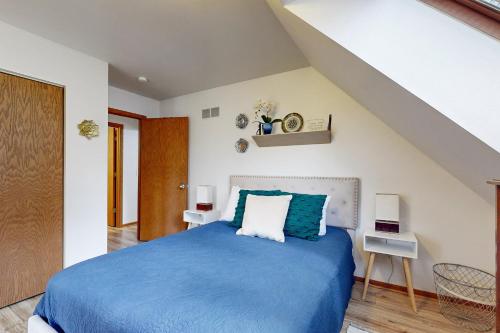 a bedroom with a blue bed and a staircase at Knotty Pines in Wisconsin Dells