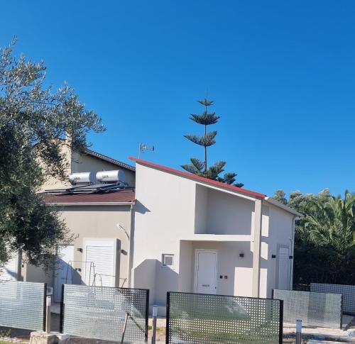 a white house with a tree on the roof at SmallHouseLefkada ΘΕΜΑ in Lefkada Town