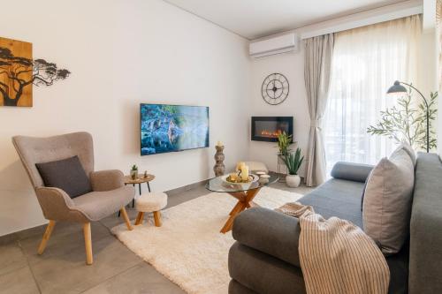 Una sala de estar con un sofá azul y sillas. en Michael's Seaside Homely Apartment In Varkiza, en Varkiza